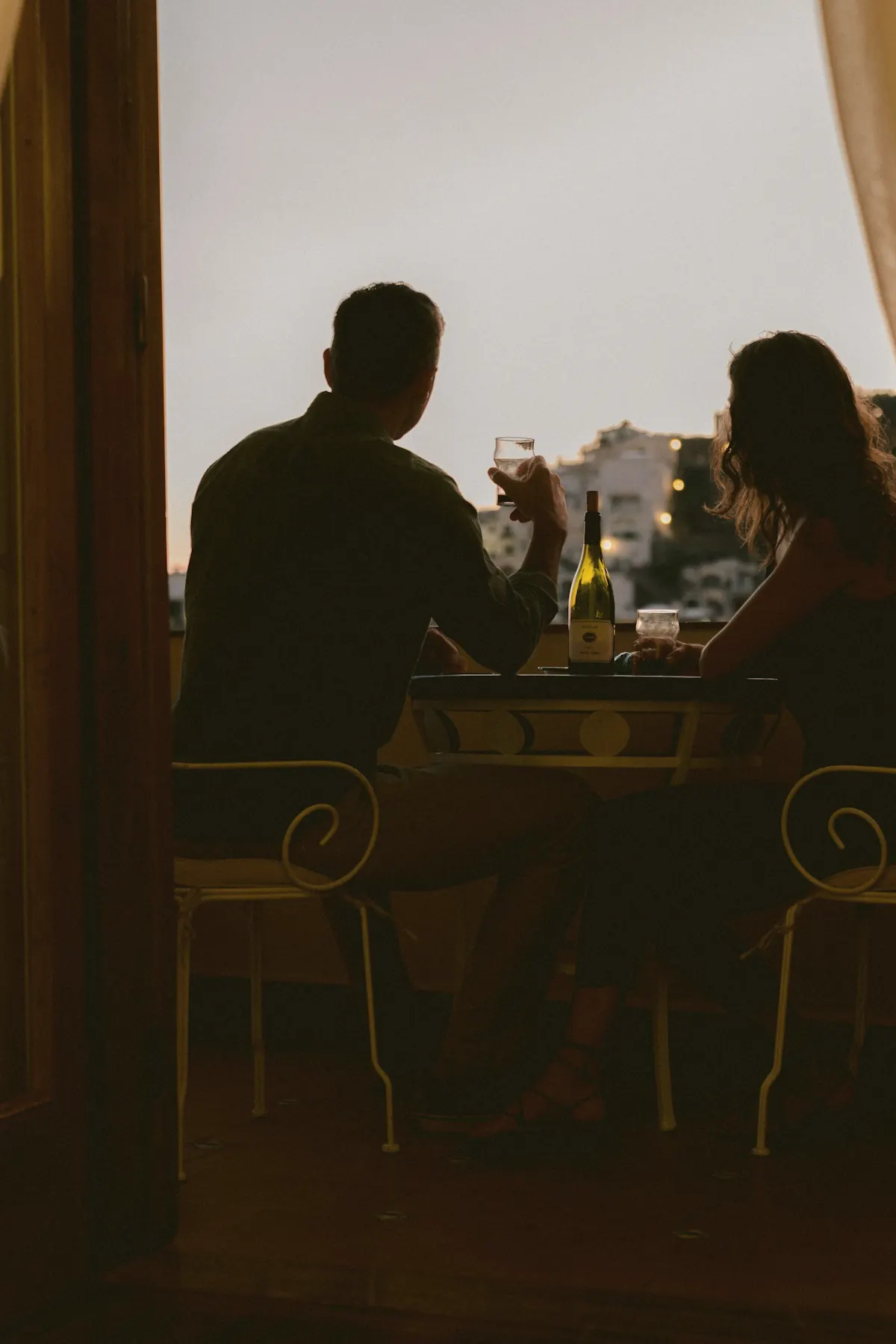 A couple at a window table at dusk, the town beyond